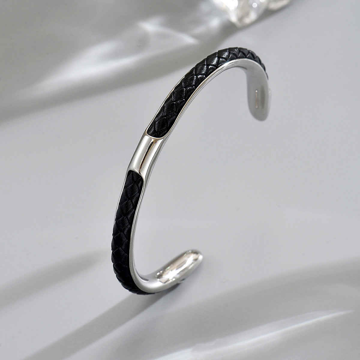 Men's Inlay Arc Cuff in black and silver-tone stainless steel – original angled detail of braided inlay and open ends