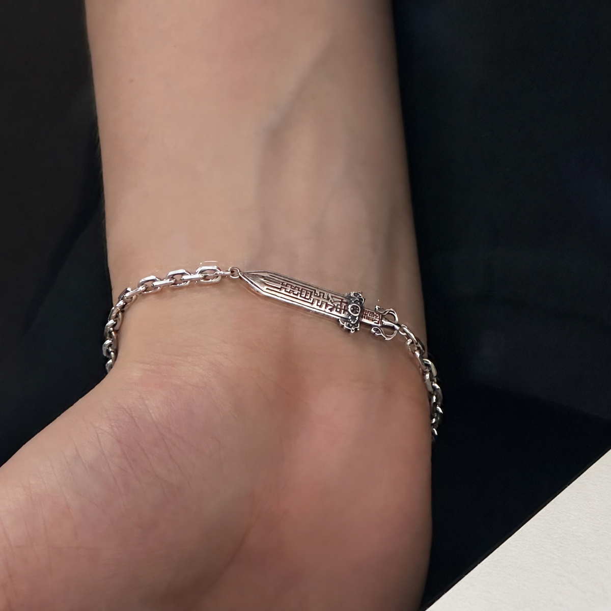 Men's Talisman Sword Sterling Silver Bracelet in Sterling Silver – contextual scene, on wrist with black cotton