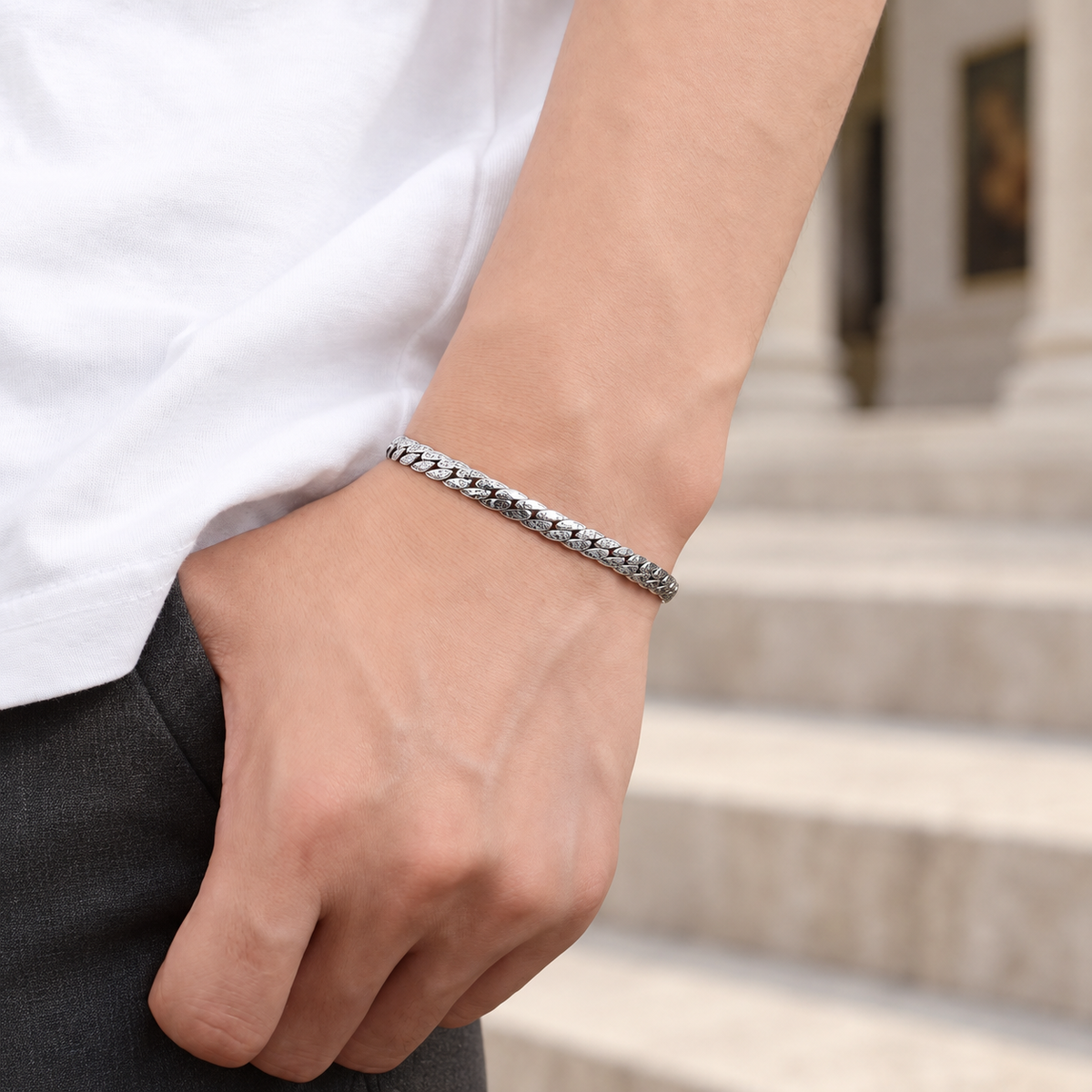 Men's Faceted Curb Bracelet in Sterling Silver – contextual scene, on wrist beside stone steps