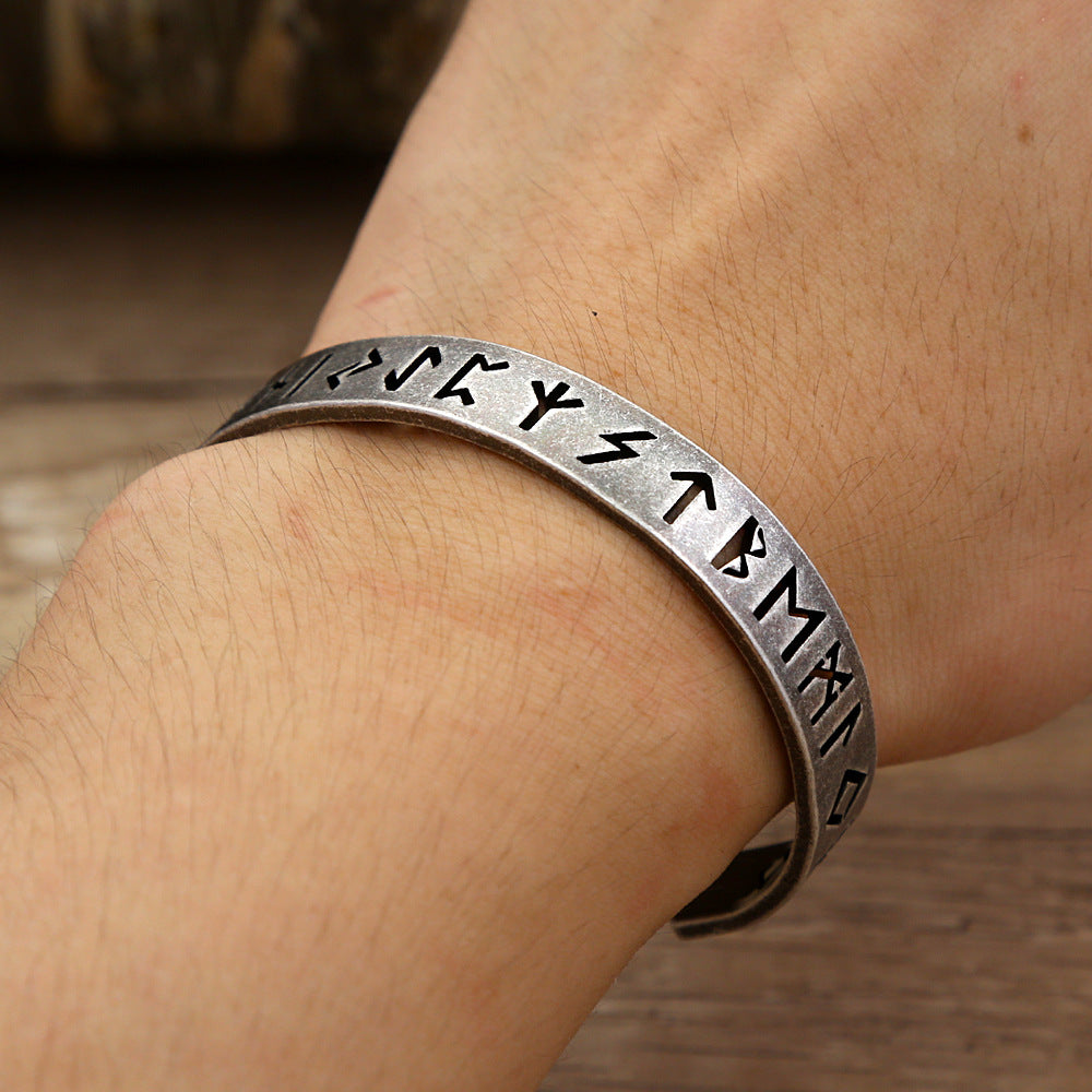 Men's Runic Cutout Cuff in Silver-Tone Steel – contextual scene, on wrist over a wooden tabletop