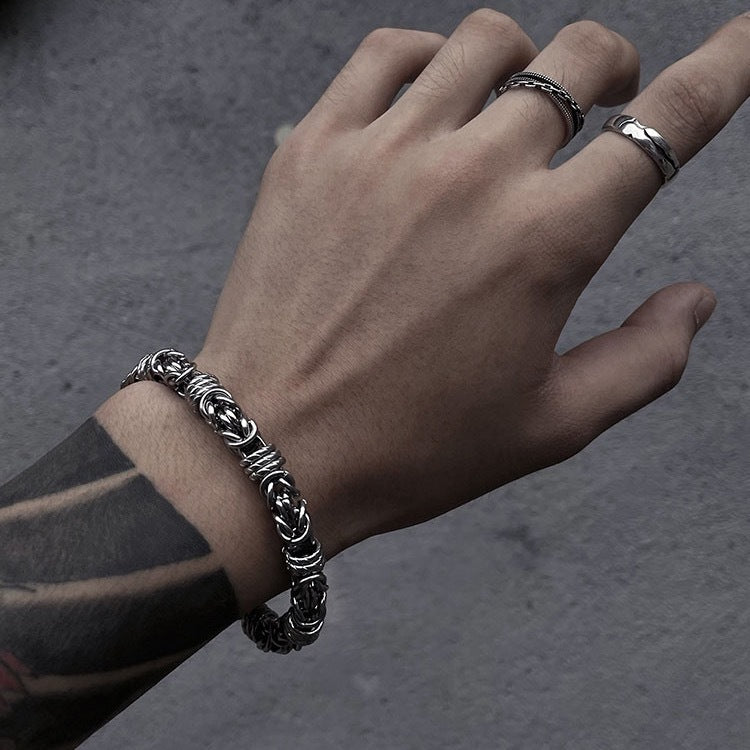 Men's Coiled Ring Byzantine Bracelet in silver-tone stainless steel – contextual scene on wrist with dark clothing
