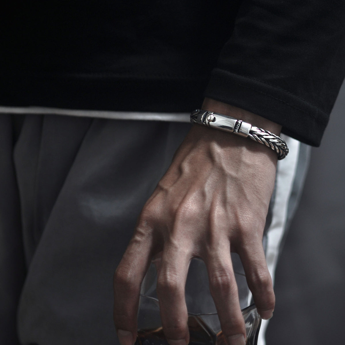 Men's Leaf Edge Weave Bracelet in Sterling Silver – contextual scene, on wrist with dark tailoring