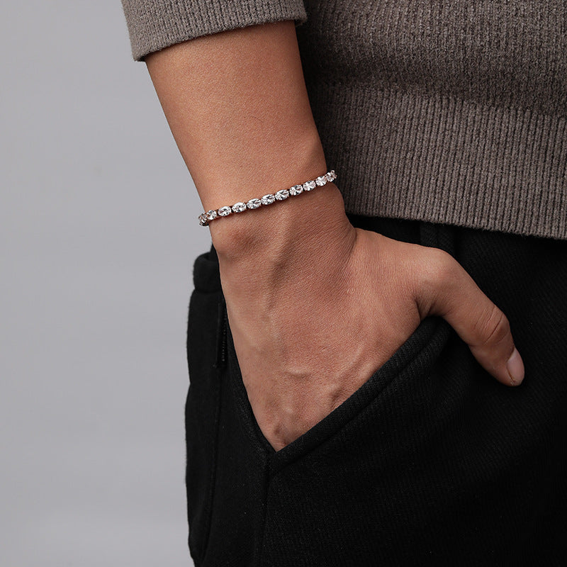 Men's Oval Light Tennis Bracelet in Silver-Tone Steel – contextual scene, on wrist with a taupe knit sleeve and black trousers