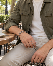 Cross Charm Curb Bracelet — contextual scene, torso and hands