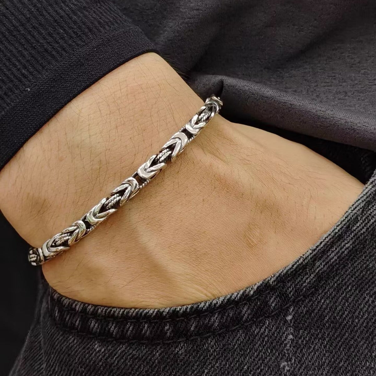 Men's Point Weave Sterling Silver Bracelet in Sterling Silver – contextual scene, on wrist with a dark knit cuff and denim