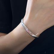 Men's Shangui Script Cuff in Sterling Silver – contextual scene, on wrist with a black sleeve