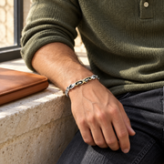 Men's Scroll Vine Sterling Silver Cuff in Silver with Gold-Tone Accents – contextual scene, on wrist with moss-green knit