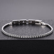 Men's Round Light Tennis Bracelet in Clear Zirconia / Silver-Tone Steel – original round-stone row, angled view