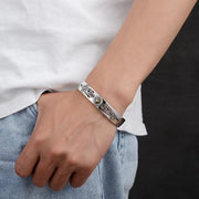 Men's Sun Scroll Cuff Bracelet in Sterling Silver – contextual scene, on wrist with a white shirt and light denim