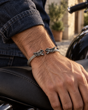 Men's Twin Dragon Cable Cuff in Silver-Tone Steel – contextual scene, on wrist beside a motorcycle