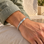 Men's Square Barrel ID Bracelet in Silver-Tone Steel – contextual scene, on wrist with sage linen