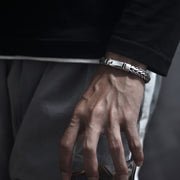 Men's Leaf Edge Weave Bracelet in Sterling Silver – contextual scene, on wrist with dark tailoring